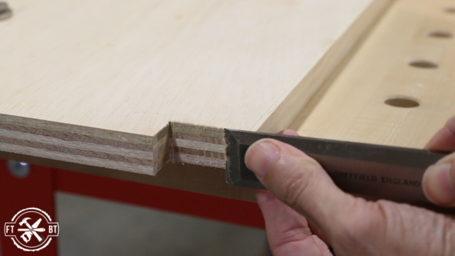 using a chisel to clean up a cut on a wooden panel