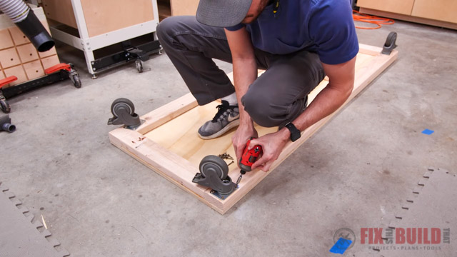 attaching castors to base of lumber cart