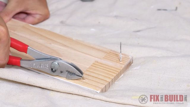 prying nails out of baseboard with slip joint pliers