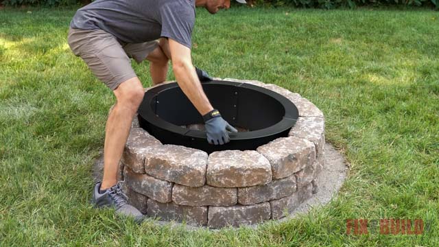 lowering fire pit ring into diy stone fire pit