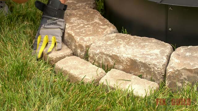 laying small paver around stone fire pit