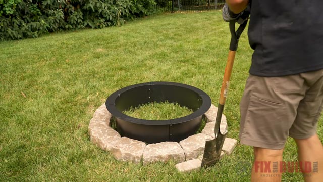 Cutting a line in grass around stone fire pit